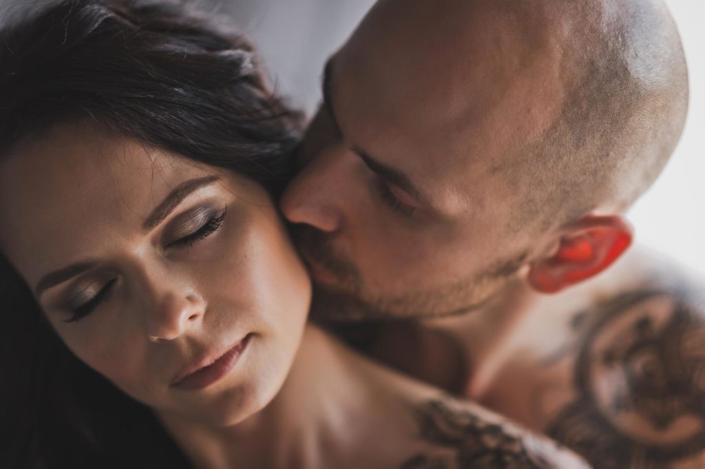 Ein Mann küsst leidenschaftlich den Hals einer Frau, die die Augen geschlossen hält – ein Symbol für unkontrollierbares sexuelles Verlangen.