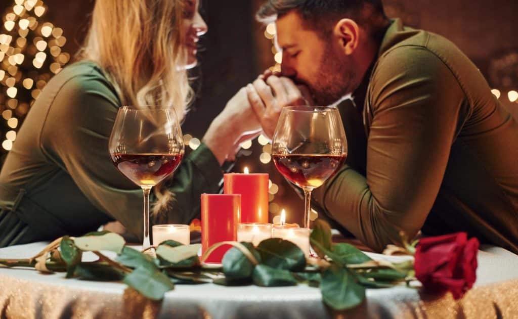 Ein stilvolles Paar genießt ein romantisches Abendessen mit Rotwein und Kerzenlicht. Die luxuriöse Atmosphäre und die gehobene Gesellschaft unterstreichen die Exklusivität eines High Class Escort Services.